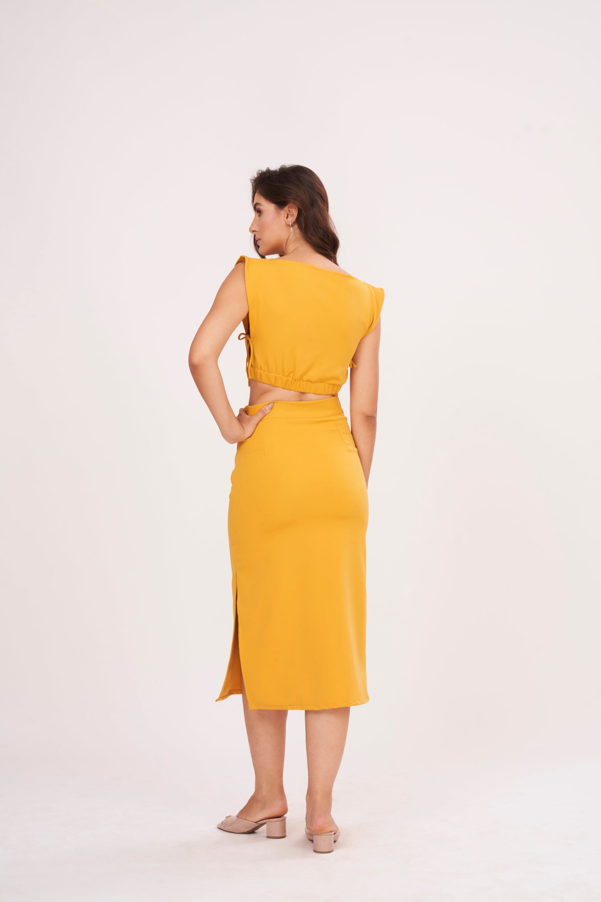 Mustard yellow long skirt with high-waisted design and side slit, made from high-quality muslin fabric. Side cut adds drama and allure. Suitable for dressing up or down.