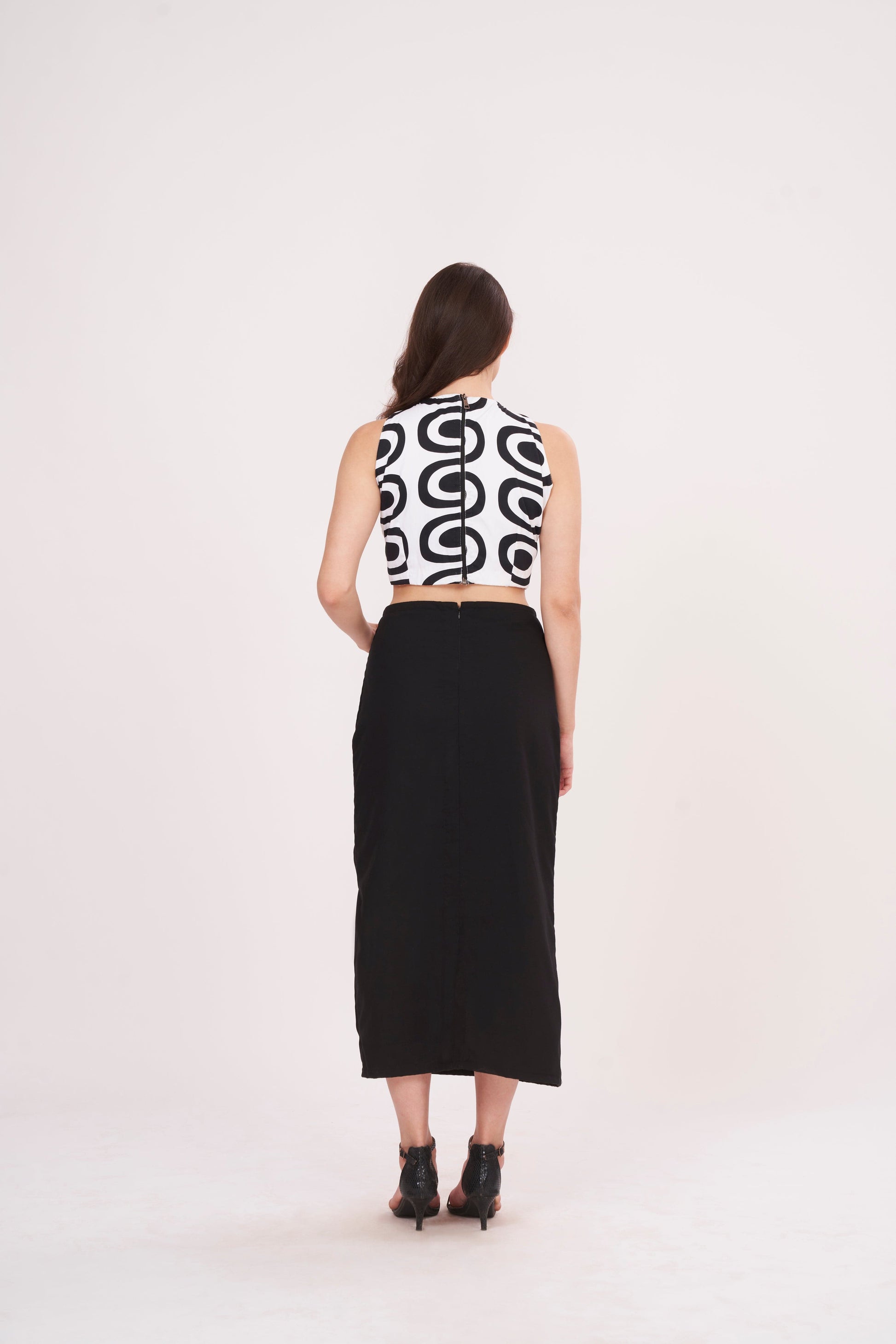 Square-shaped crop top with bold abstract print, paired with black thigh-high slit skirt for a striking ensemble