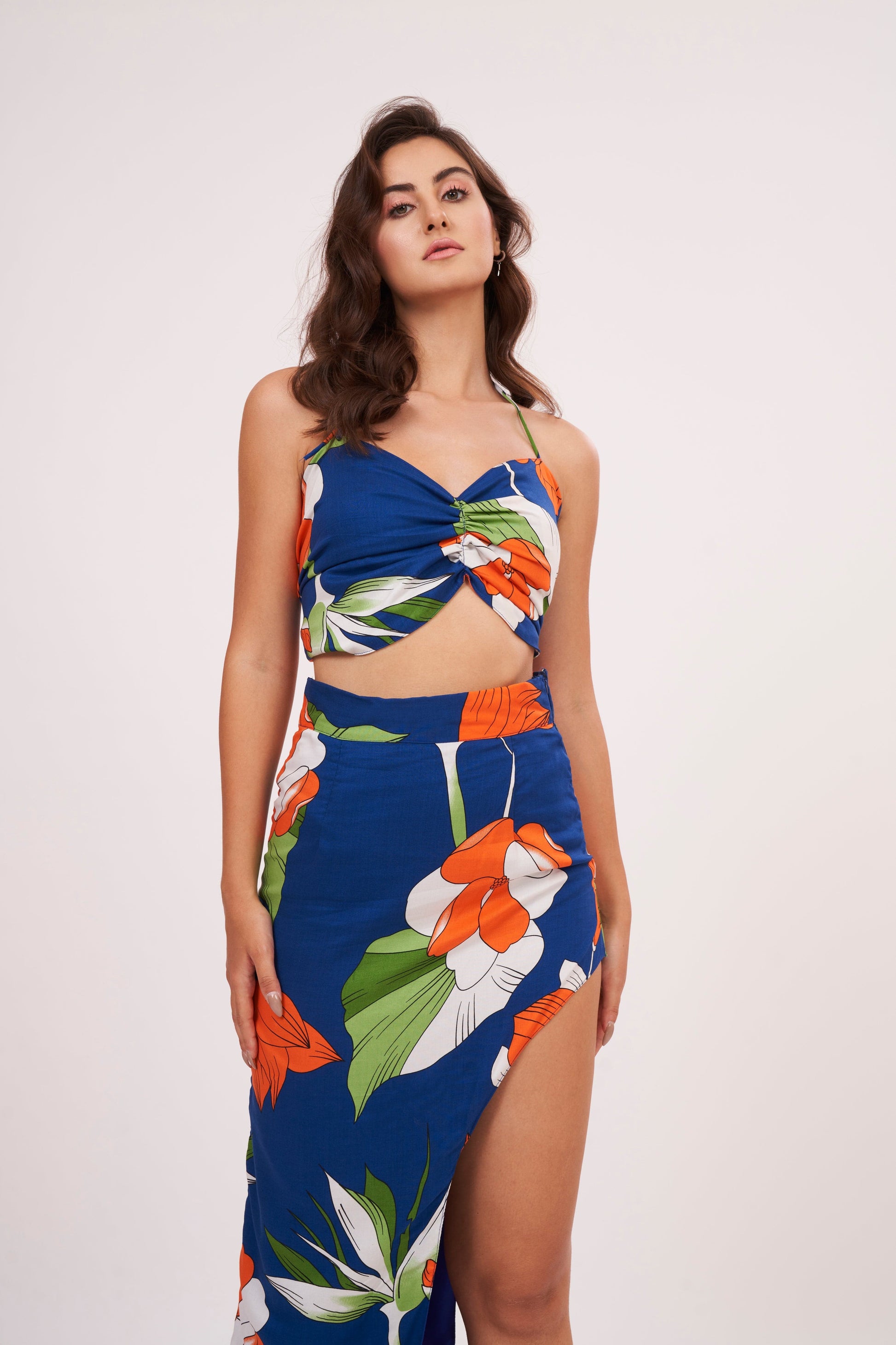 Designer crop top with intricate floral patterns in bold hues. Ruched gathering along bodice for snug fit. Made from high-quality muslin, perfect for any occasion.