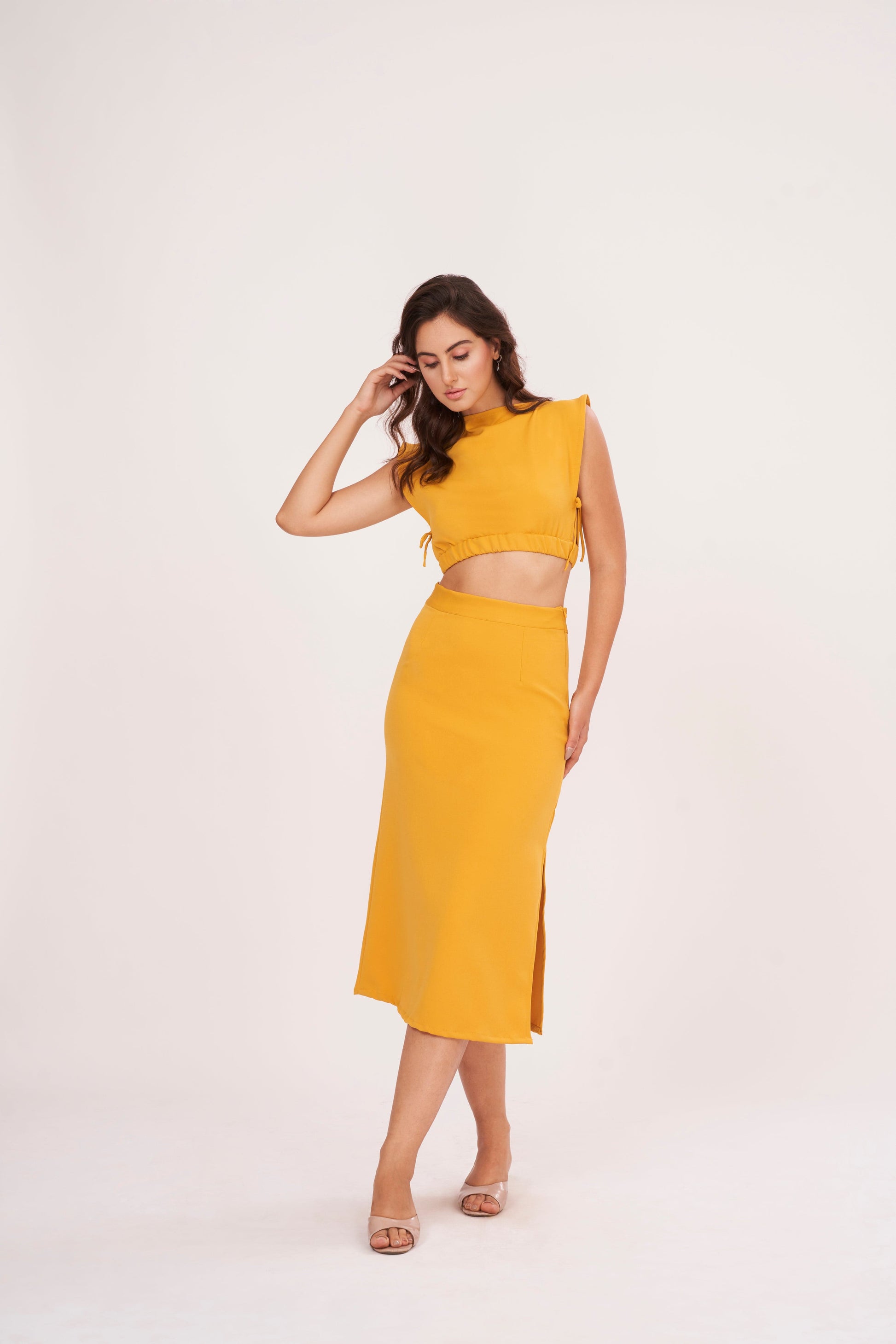 Mustard yellow long skirt with high-waisted design and side slit, made from high-quality muslin fabric. Side cut adds drama and allure. Suitable for dressing up or down.