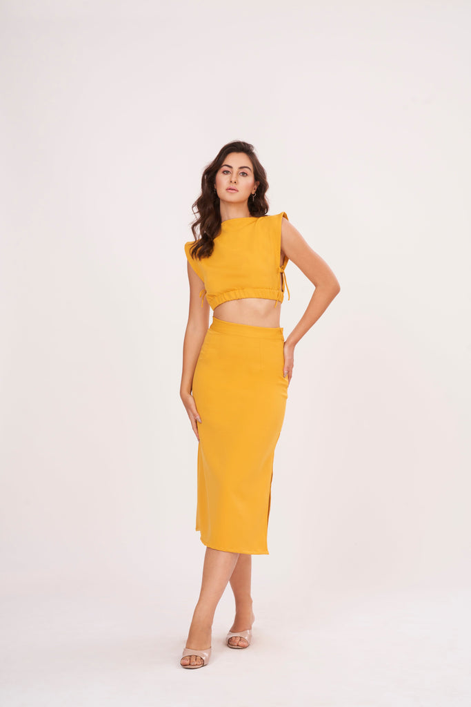 Mustard yellow long skirt with high-waisted design and side slit, made from high-quality muslin fabric. Side cut adds drama and allure. Suitable for dressing up or down.