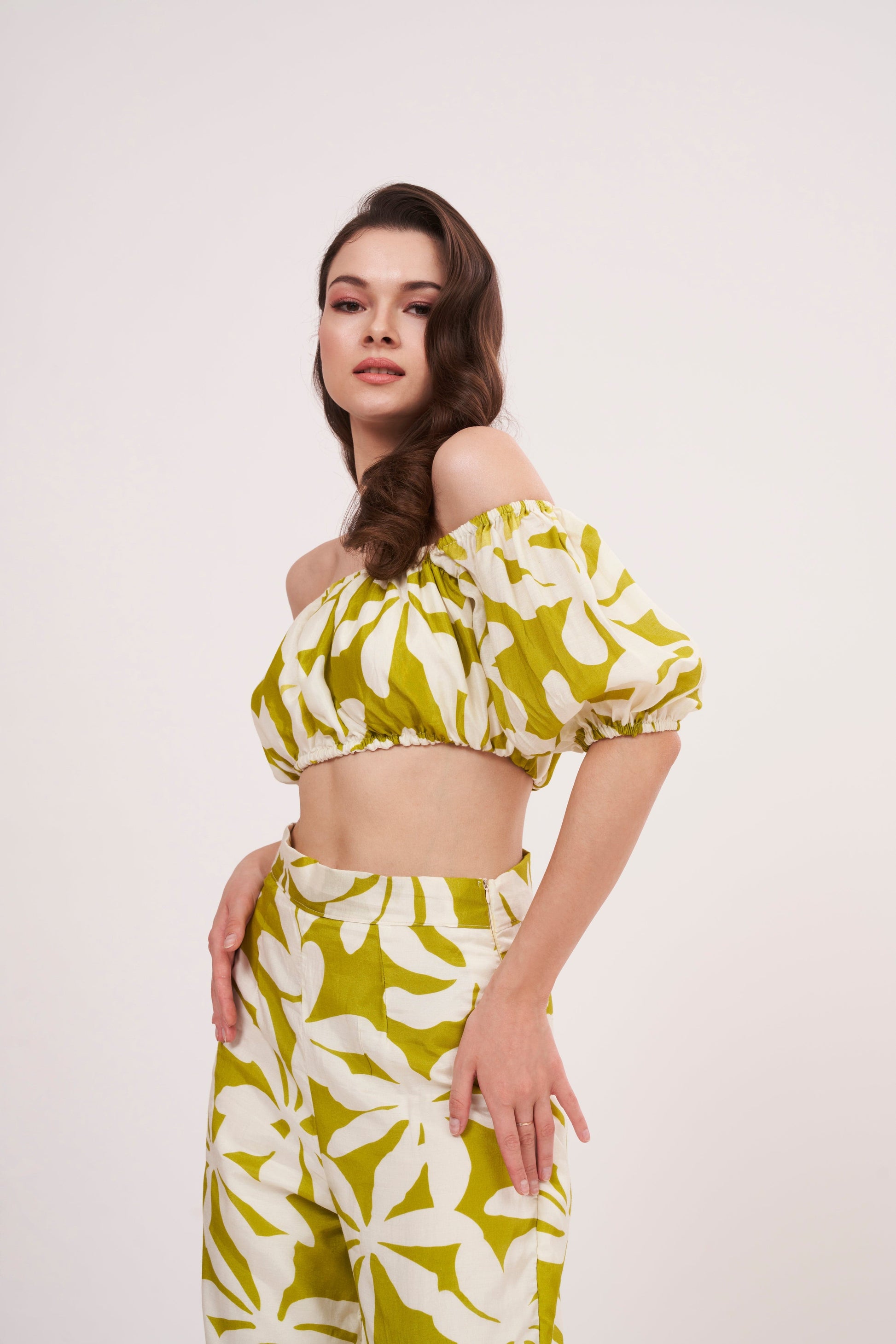 Elasticated-sleeve tube crop top with off-shoulder floral design, perfect for summer outings and casual evening dinners, featuring a green geometric print.