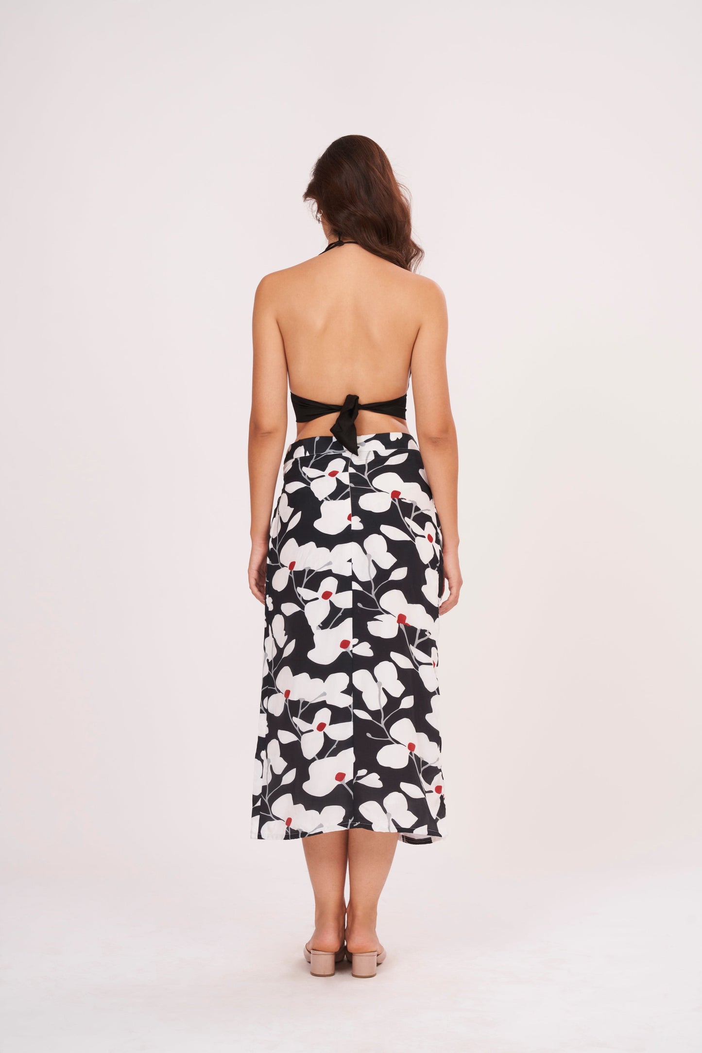 Black halter neck top and floral skirt with captivating front opening and alluring center gap, perfect for beach vacations and showcasing curves.