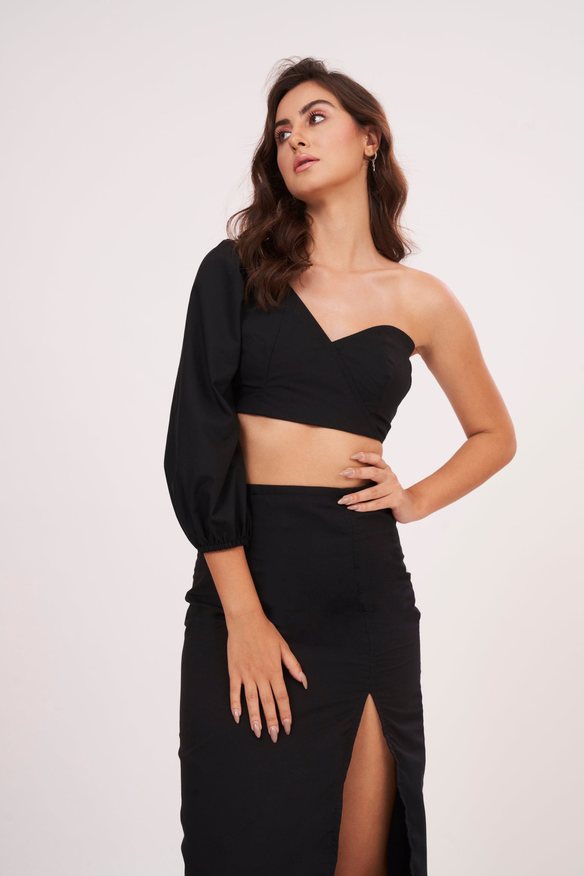 Elegant one-sleeve black top with asymmetrical design, draping across chest and shoulder, made from luxurious muslin fabric