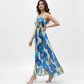 Ivory maxi dress in lightweight Chinon featuring a bold blue floral print and a flowing pleated skirt, perfect for garden parties and daytime celebrations.