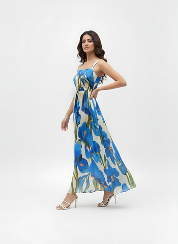 Ivory maxi dress in lightweight Chinon featuring a bold blue floral print and a flowing pleated skirt, perfect for garden parties and daytime celebrations.