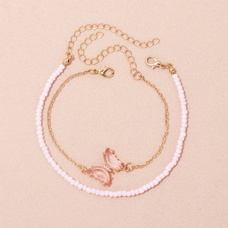 This handcrafted pink butterfly anklet combines earthy beads with a whimsical charm, making it an ideal accessory to brighten up your vacation wardrobe