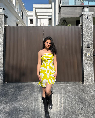 Influencer walking in yellow tube dress, reflecting a chic city-resort blend.
