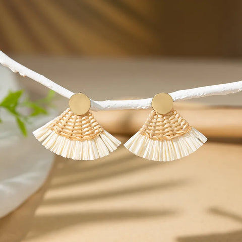 Natural woven straw fan earrings with a small gold metallic stud, a lightweight and trendy accessory for summer outfits.