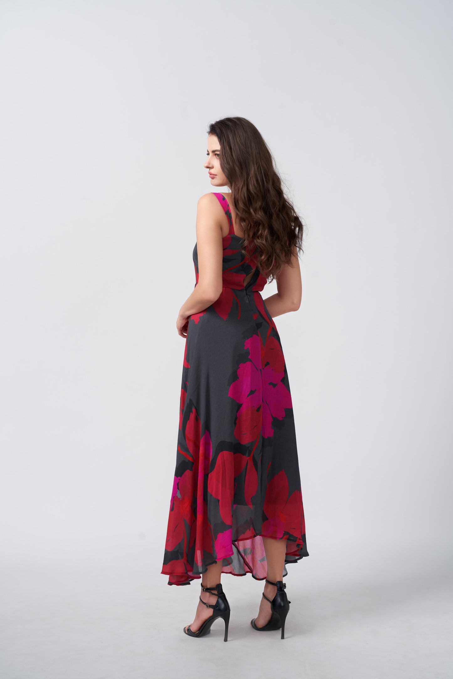 Back view of a pink and black floral print chinon midi dress with a flowing fit