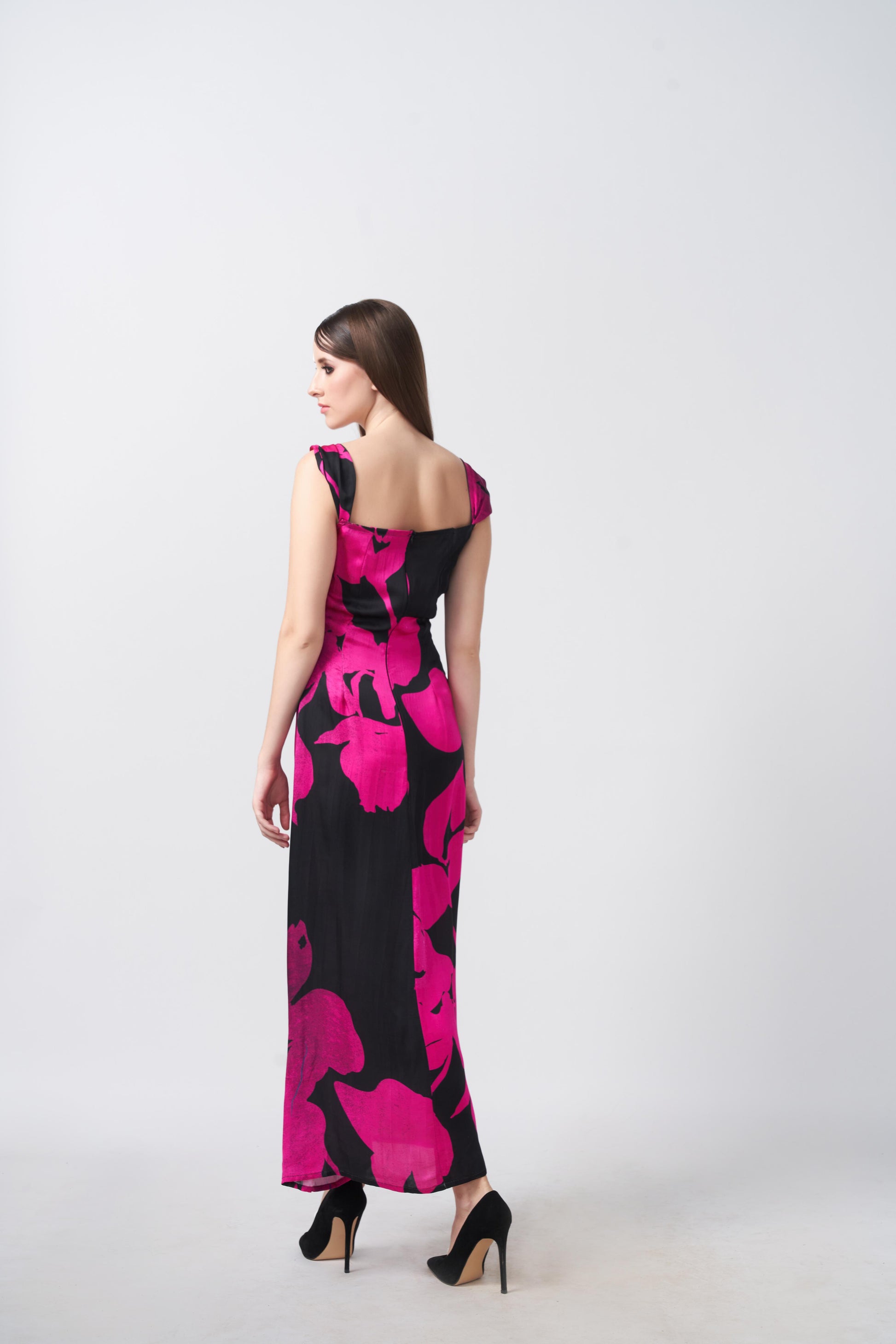 Back view of a pink and black floral satin ankle-length dress with shoulder straps and a smooth drape