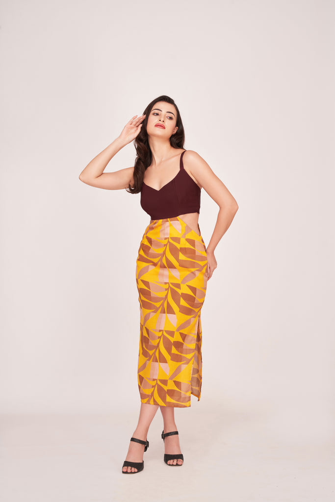Model wearing a maroon bodice and abstract print satin midi dress, front-facing with hand resting on head.