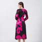 Back view of model highlighting the in pink and black floral midi dress with long sleeves.