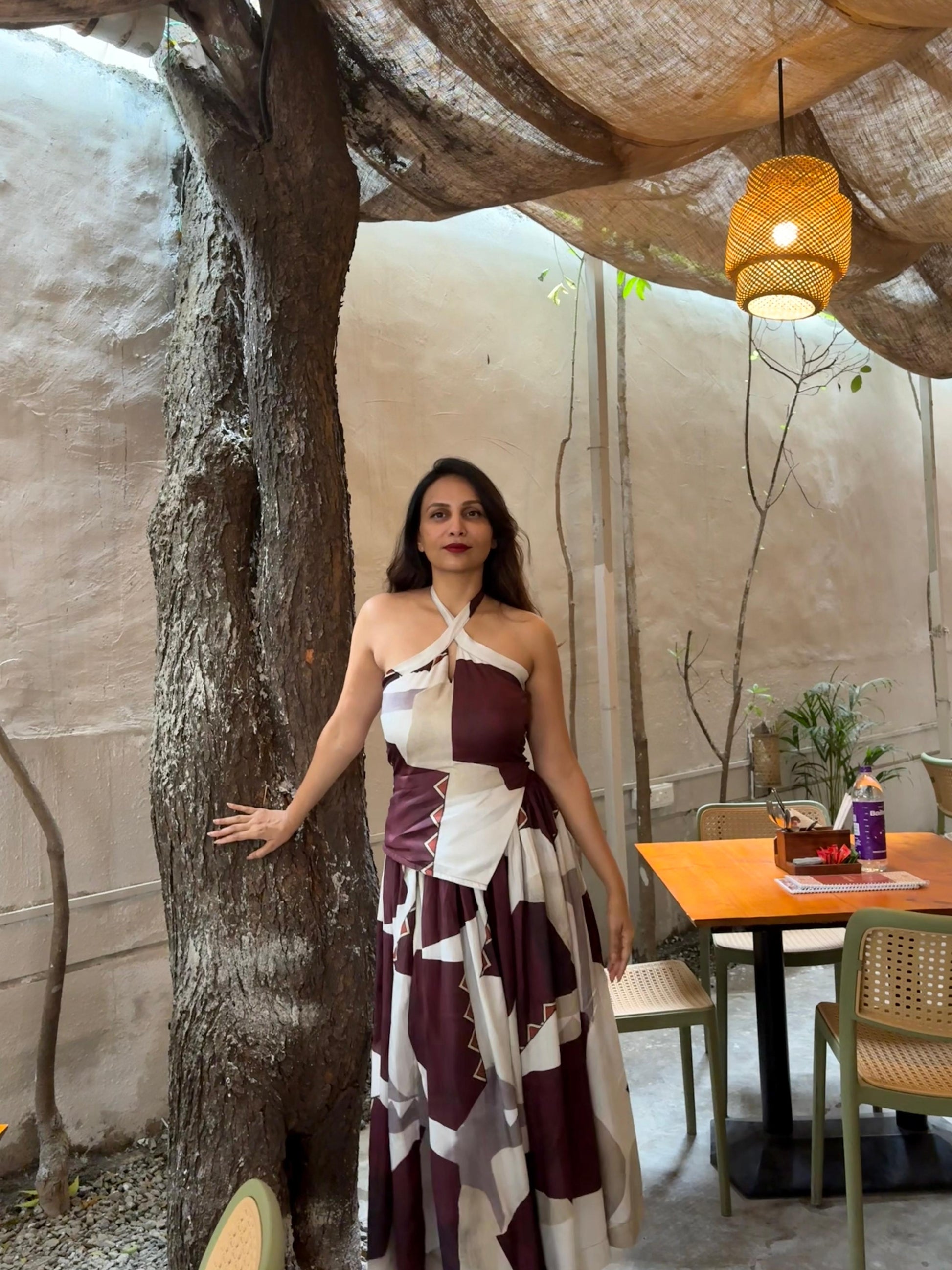 Halter-neck two-piece set with a knot-detail cropped top and a high-waist wrap skirt in a geometric abstract print in mocha and cream tones