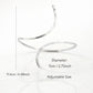 A minimalist silver open-cuff anklet featuring a smooth, sculpted metal finish with rounded ends, perfect for adding a modern, high-fashion edge to a gallery opening or an upscale dinner.