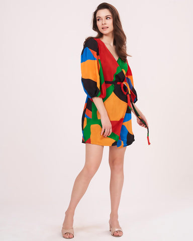 Multicolor wrap dress featuring a bold geometric print in vibrant shades of red, green, orange, and blue.