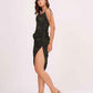 Side-facing pose of model in ruched floral midi dress with asymmetrical hem, showcasing fit and flare.