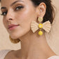Raffia bow statement earrings with yellow floral accents, ideal for a bright, breezy brunch look or accessorizing a sundress.