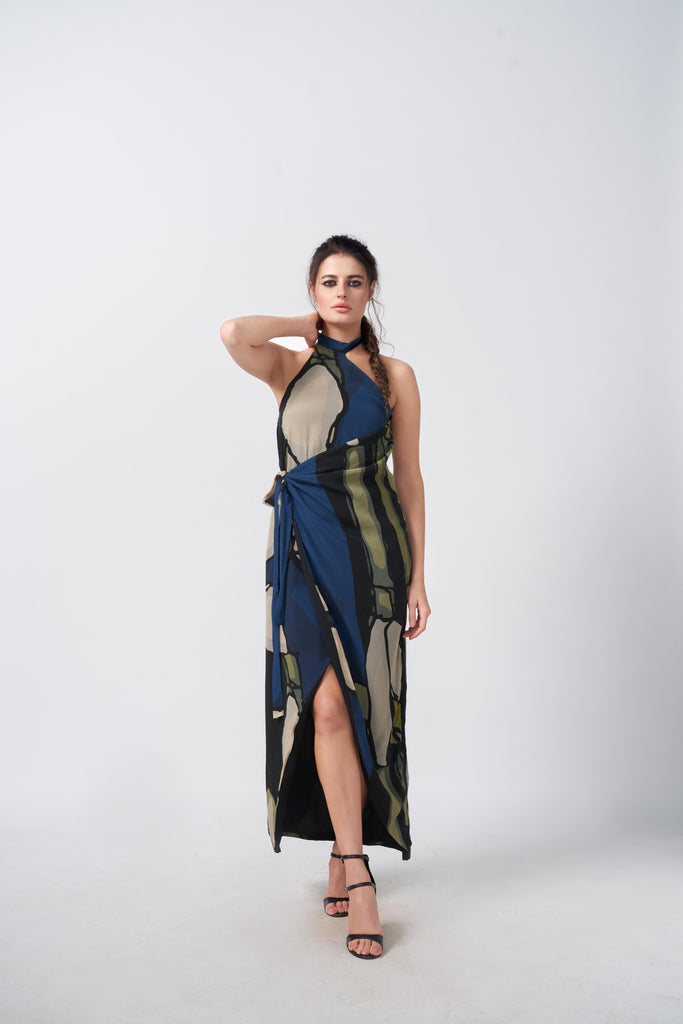 Model in a navy blue and beige abstract crepe dress with one-shoulder halter neckline and asymmetrical wrap hemline.