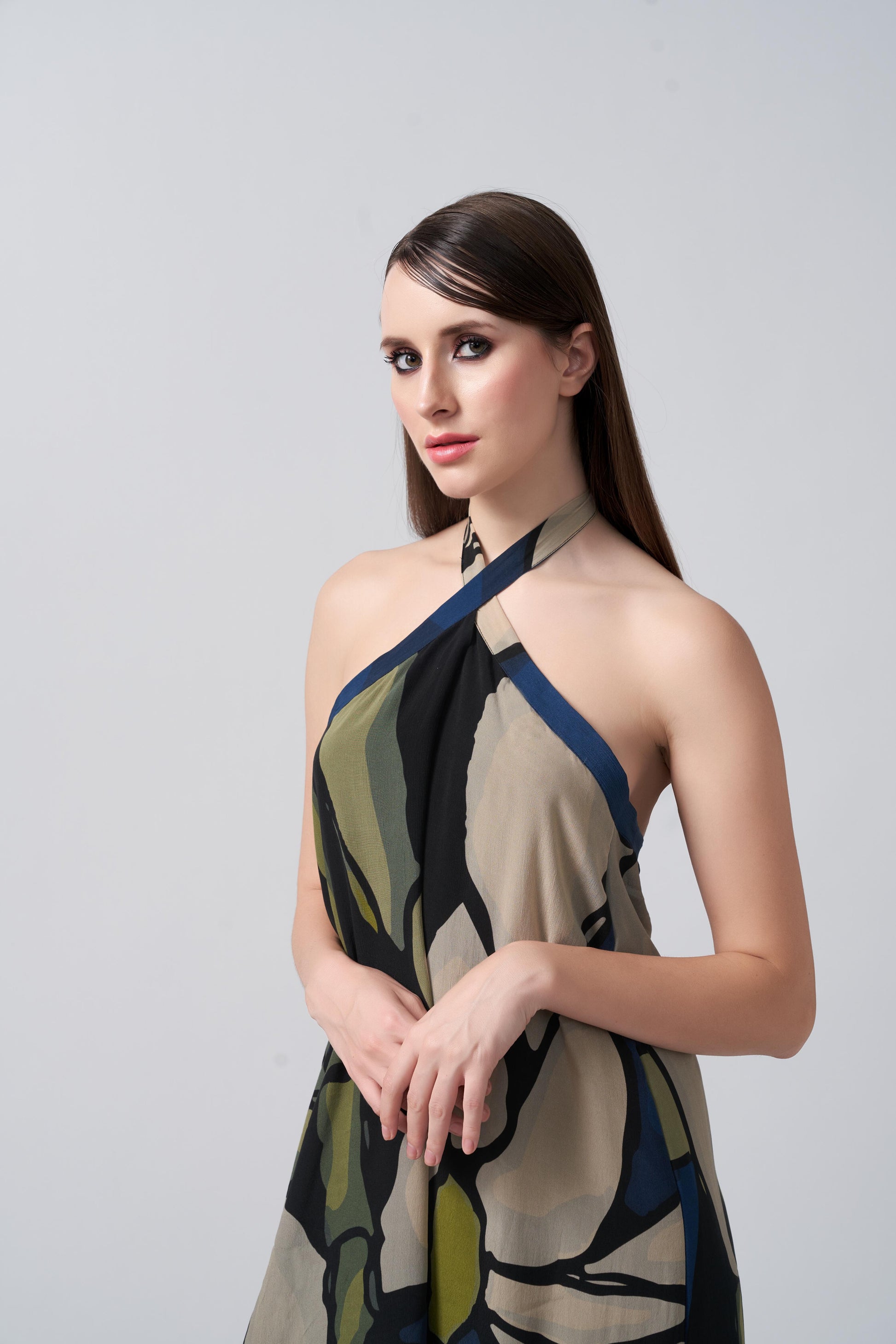 Close-up of the model in navy blue and beige halter neck dress, focusing on neckline and print.