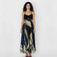 Ankle-length halter dress crafted from lightweight crepe, featuring a flowing silhouette and a navy blue and olive abstract floral print.