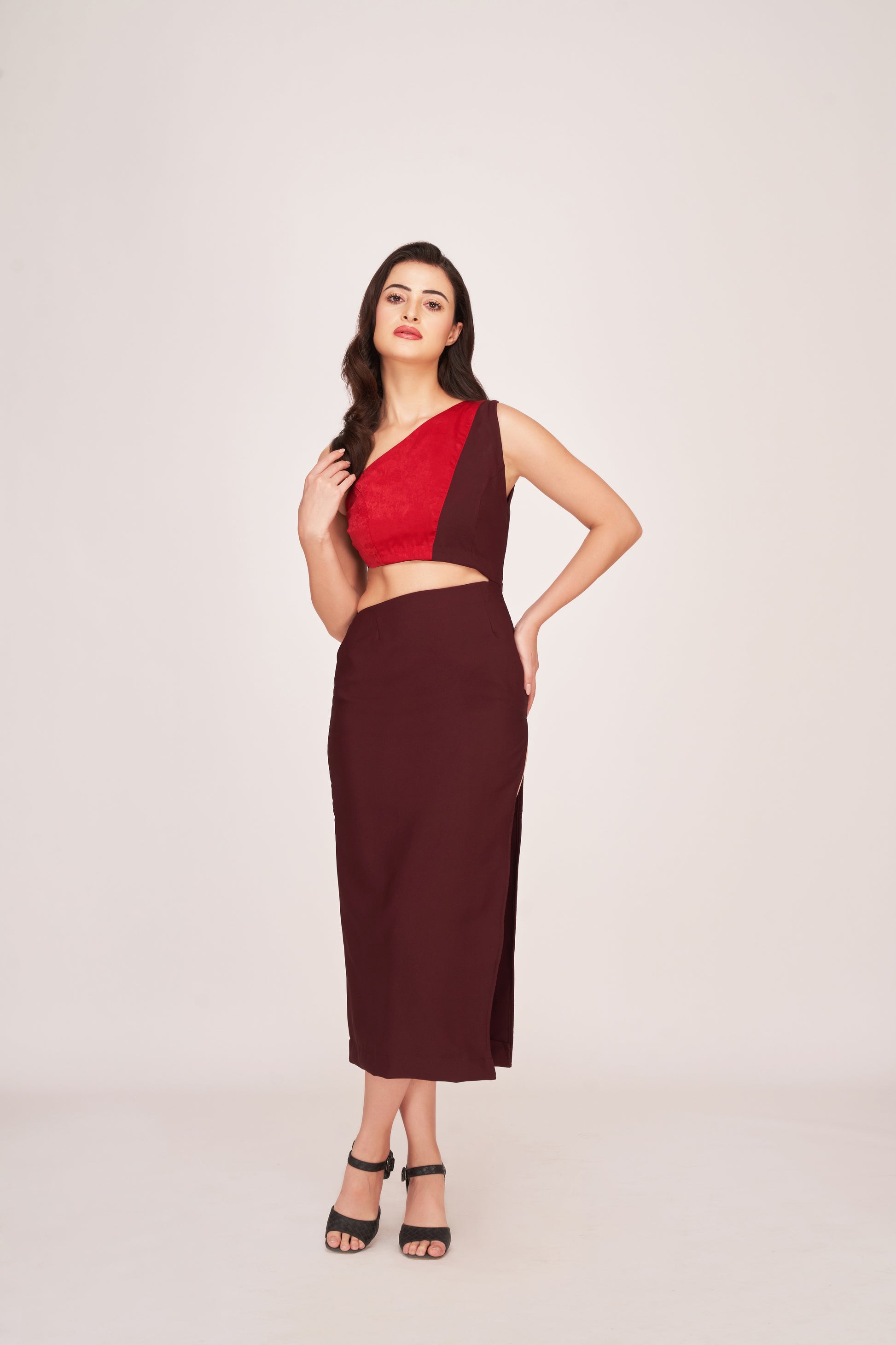 Model wearing a brown and red one-shoulder satin date night dress, standing front-facing with hands on waist.