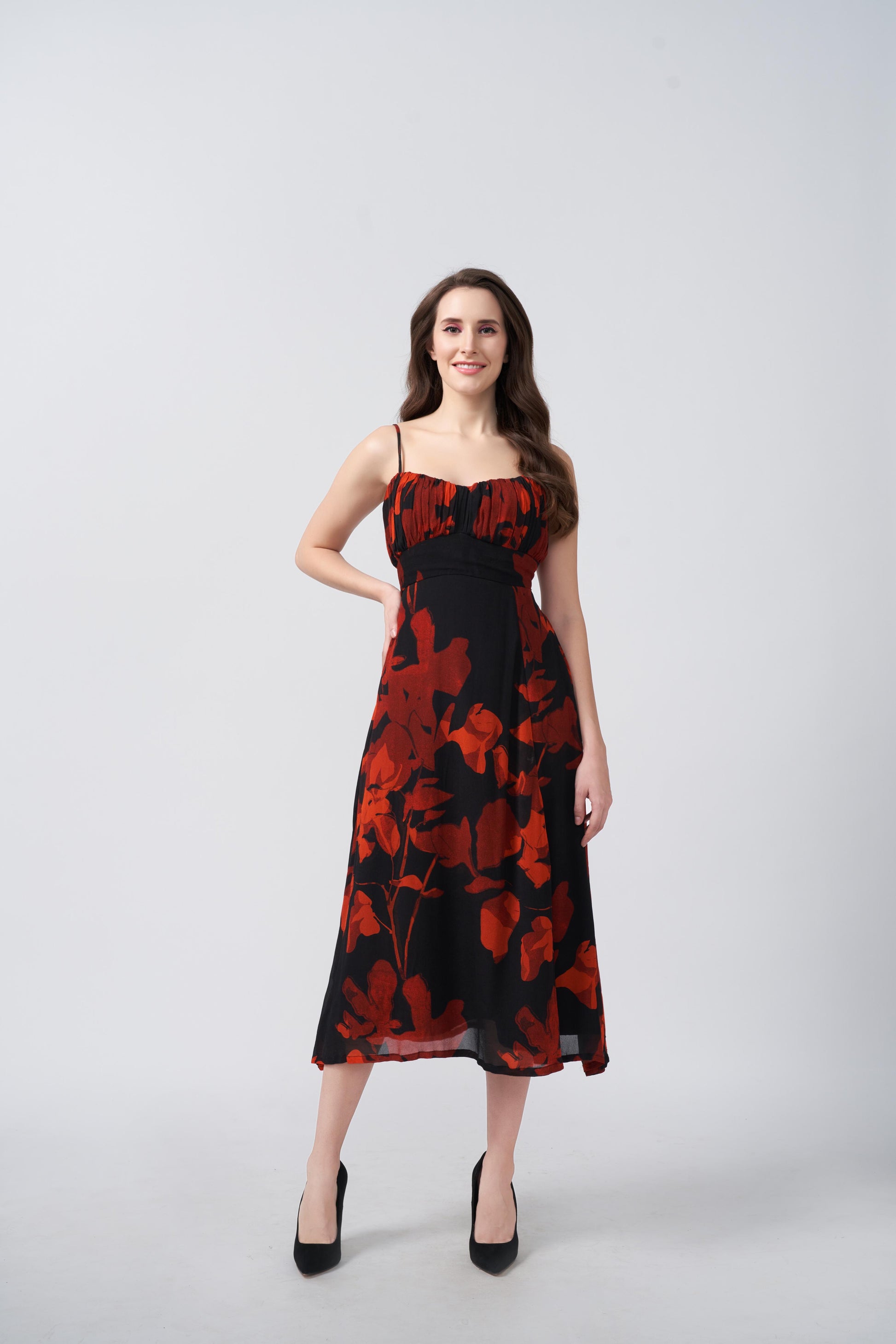 Orange and black abstract floral midi dress with a side slit, suitable for evening soirées and resort vacations