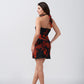 Back view of orange and black abstract short dress, highlighting the tie-back neckline and flattering fit.