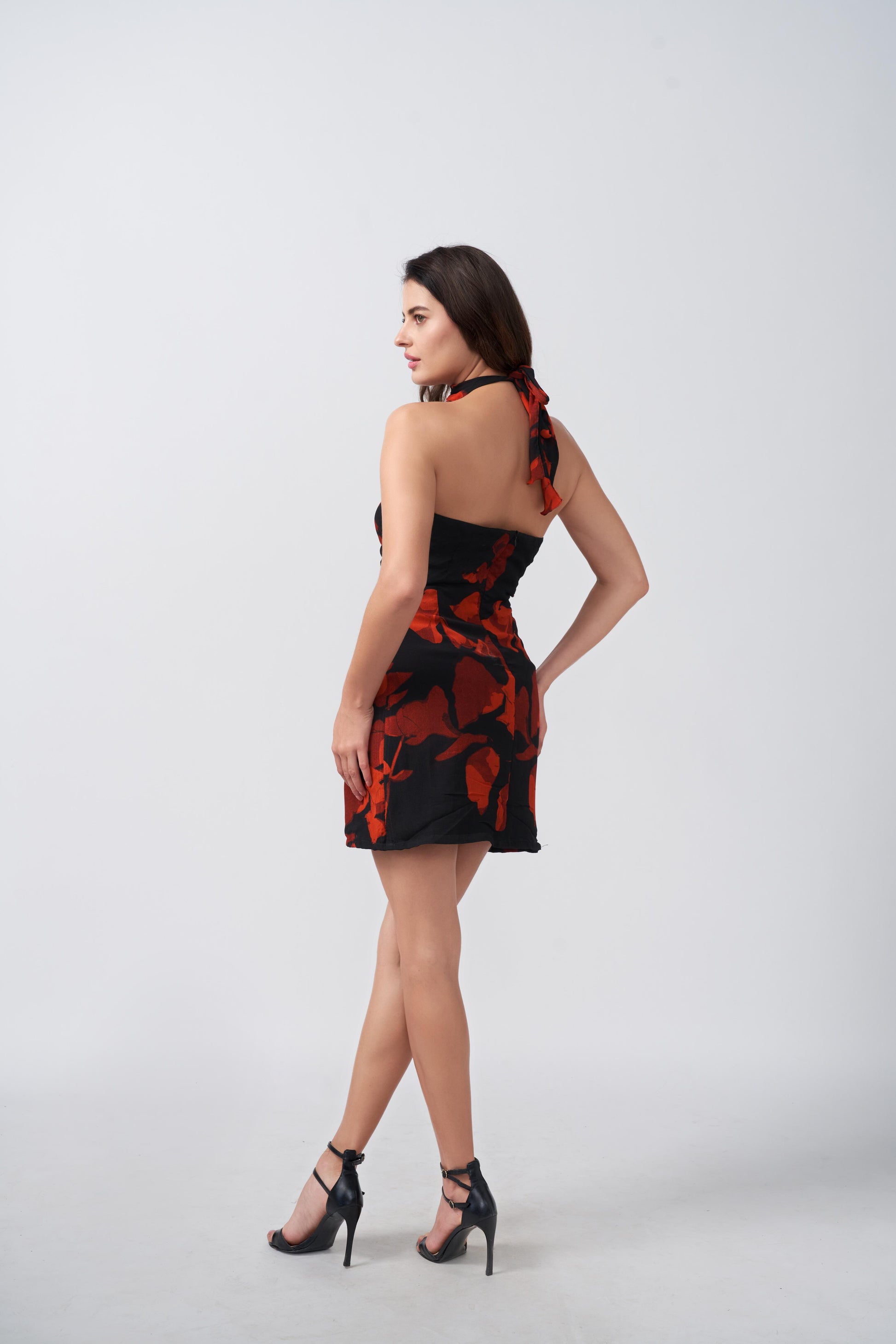 Back view of orange and black abstract short dress, highlighting the tie-back neckline and flattering fit.