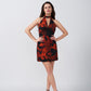 Model with hands on hips in orange and black abstract short dress, emphasizing the fitted waist and silhouette.