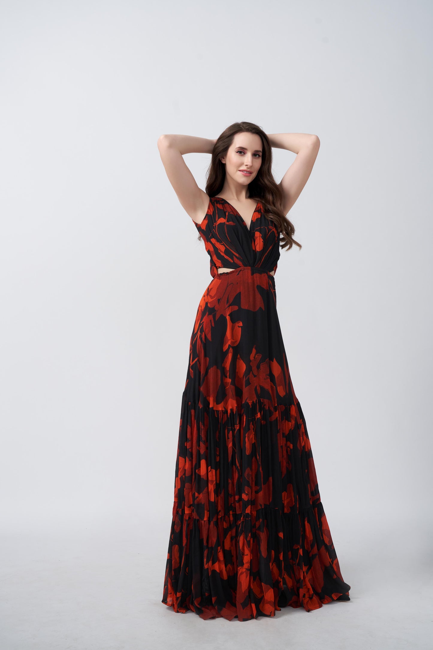 Model posing with hands raised, showcasing the flared silhouette and bold floral print.