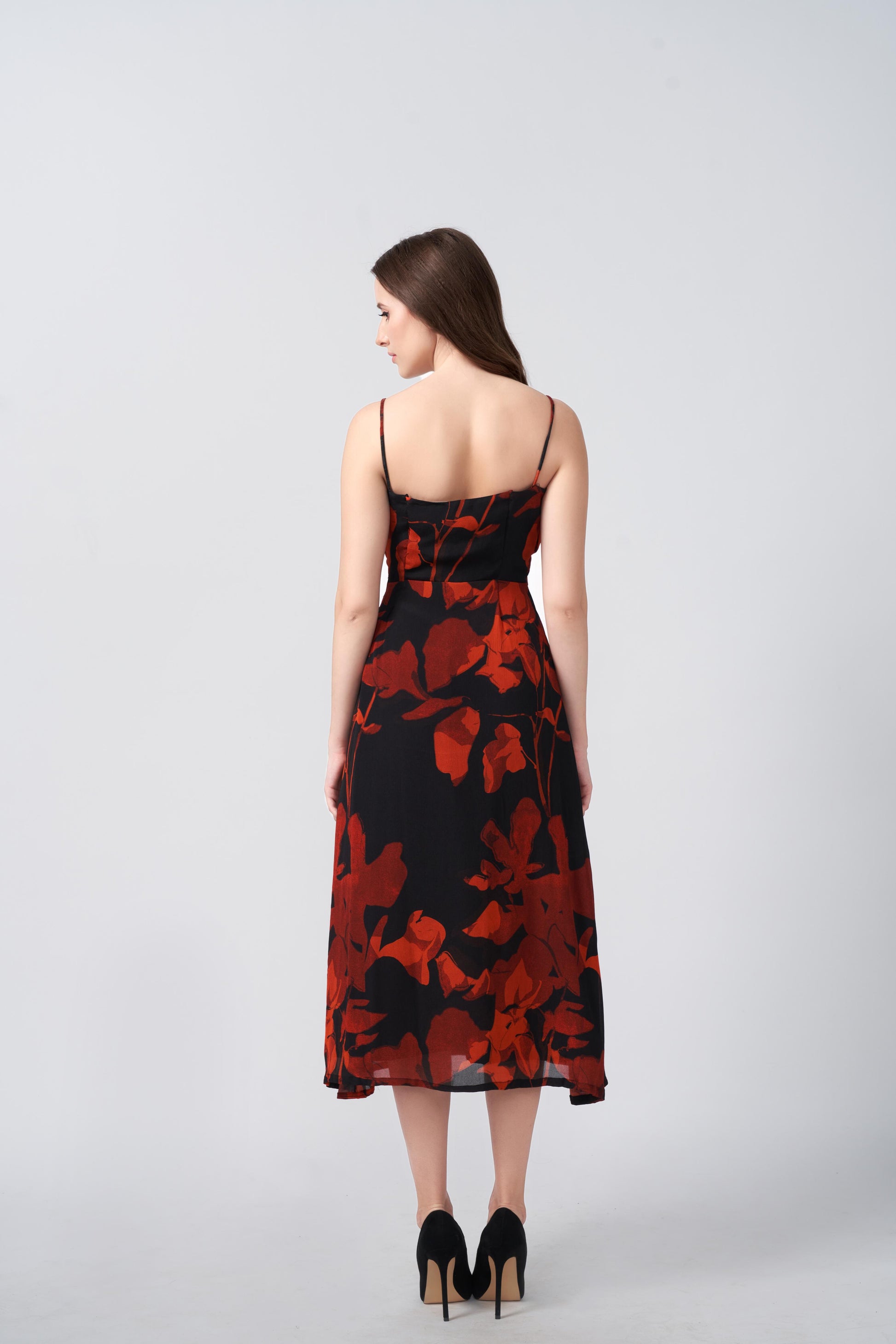 Back view of a midi-length chinon dress with spaghetti straps and a fluid silhouette