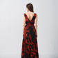 Rear angle showing waist cut-outs and tiered flow of the orange and black dress.