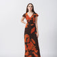 V-neck maxi dress featuring a warm palette of sunset orange and deep chocolate brown abstract botanical shapes.