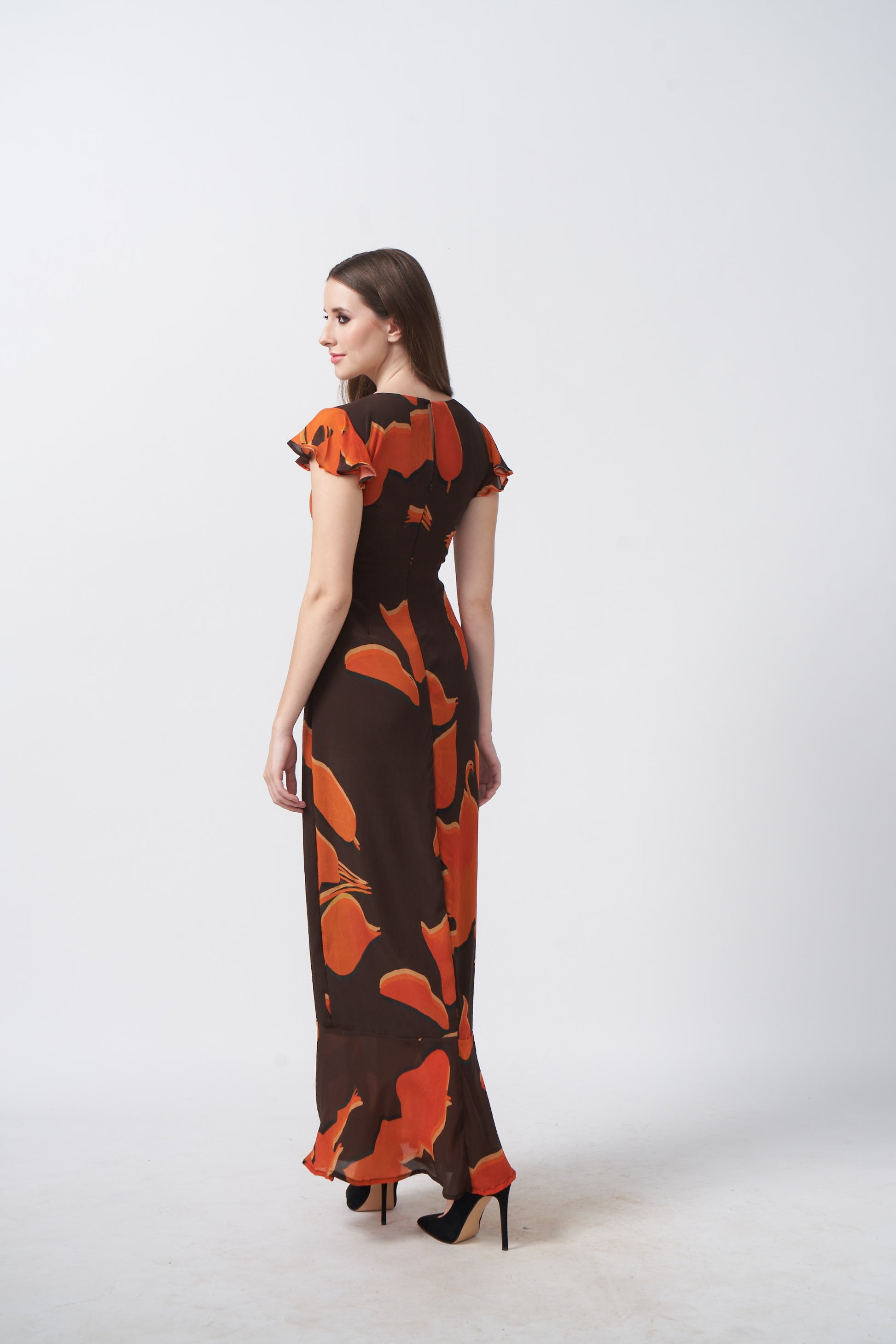 Rear view of the model displaying the dress’s back silhouette and smooth fabric fall.