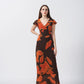 Full-length shot capturing the flow and silhouette of the orange abstract ankle-length dress.