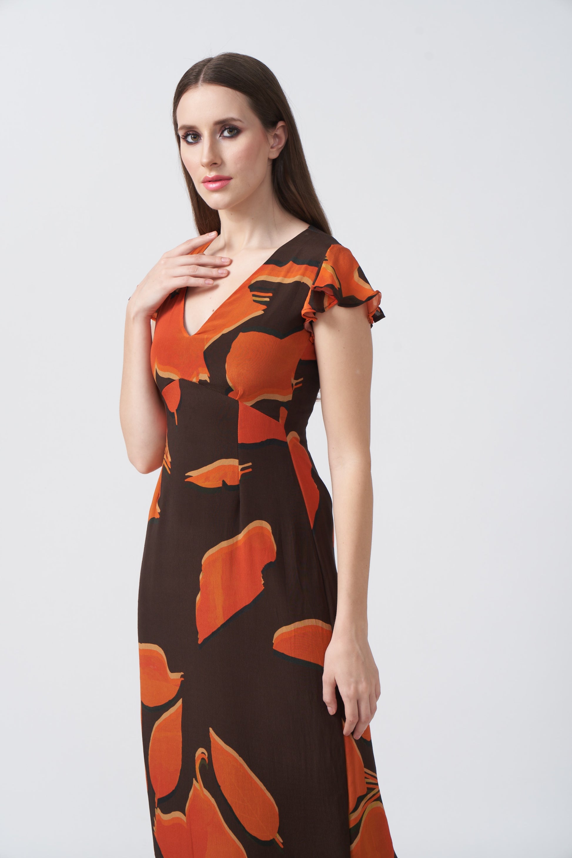 Side view of the crepe dress showing ruffle sleeve and profile of the long silhouette.