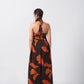 Back view of halter tie-back midi dress in vivid orange and brown print, highlighting the tie-up detail.