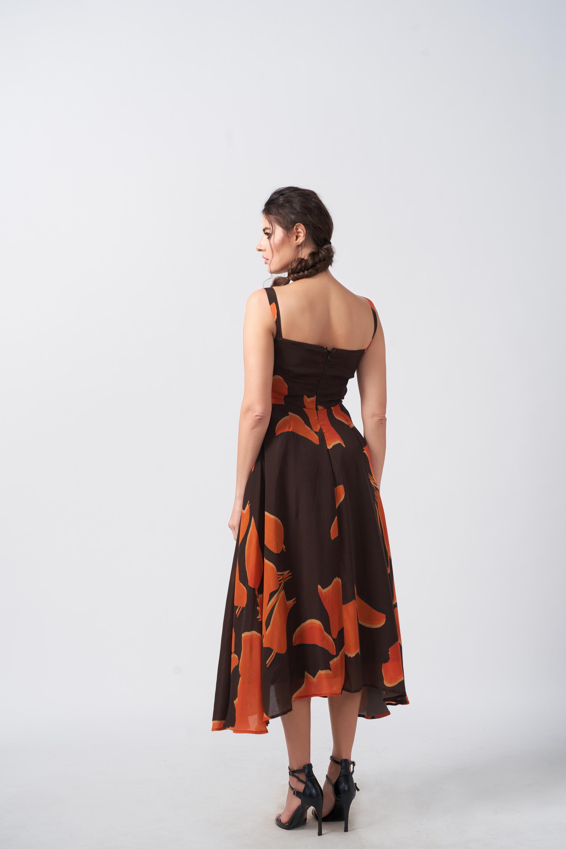 Rear view of the model in the abstract midi dress, revealing back details and dress flow.