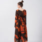 Back view of the model in an abstract midi dress with full sleeves and soft crepe flow.