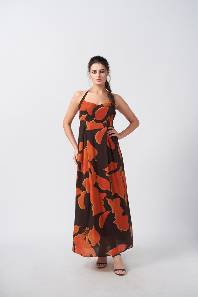 Model facing front in orange and brown abstract print halter-neck midi dress, highlighting the relaxed silhouette.