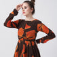 Close-up of the model in an abstract knot-front midi dress, highlighting the neckline and sleeve design.