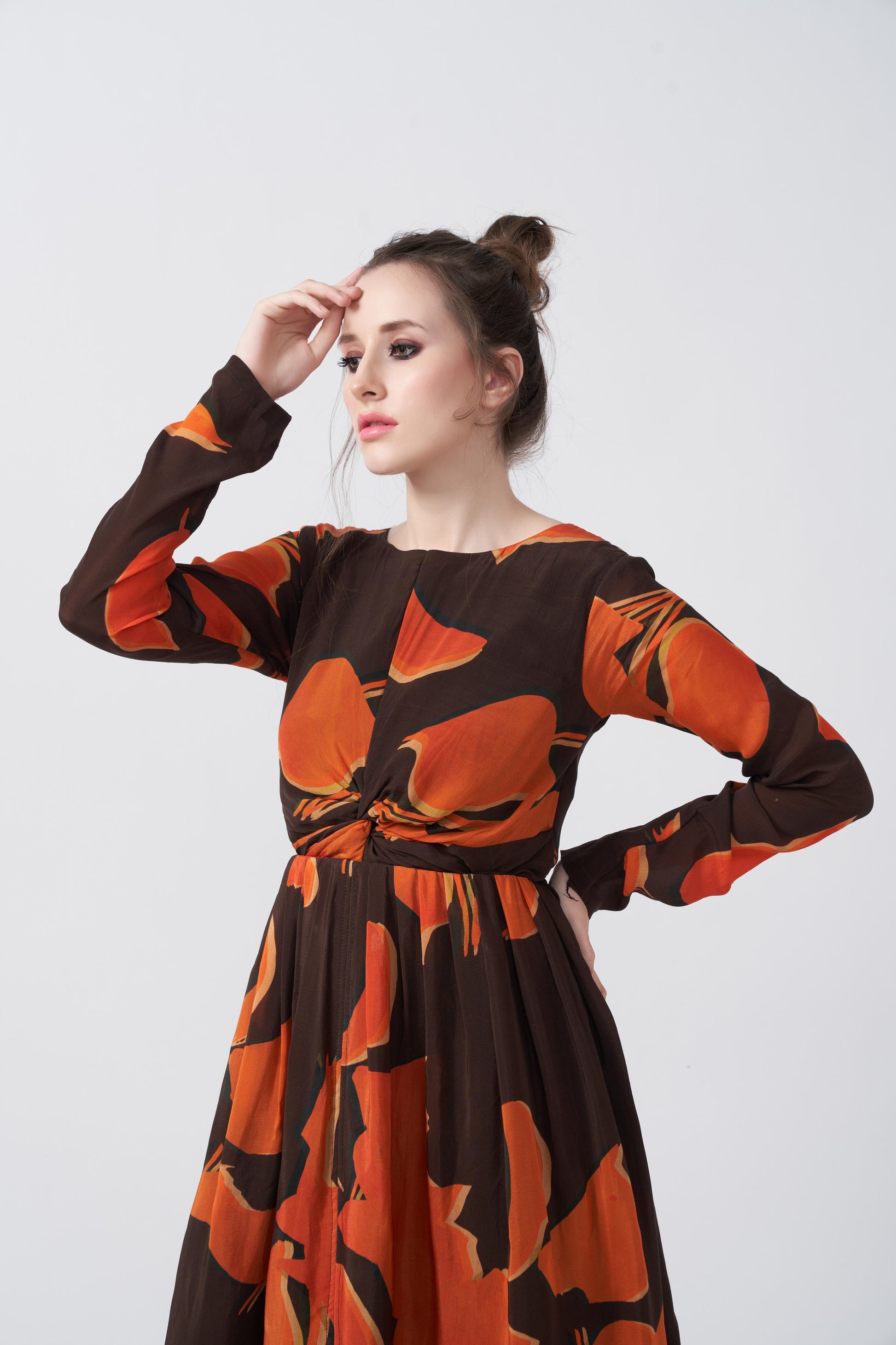 Close-up of the model in an abstract knot-front midi dress, highlighting the neckline and sleeve design.