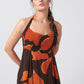 Close-up of model in halter neck orange abstract dress, focusing on the neckline and upper bodice fit.