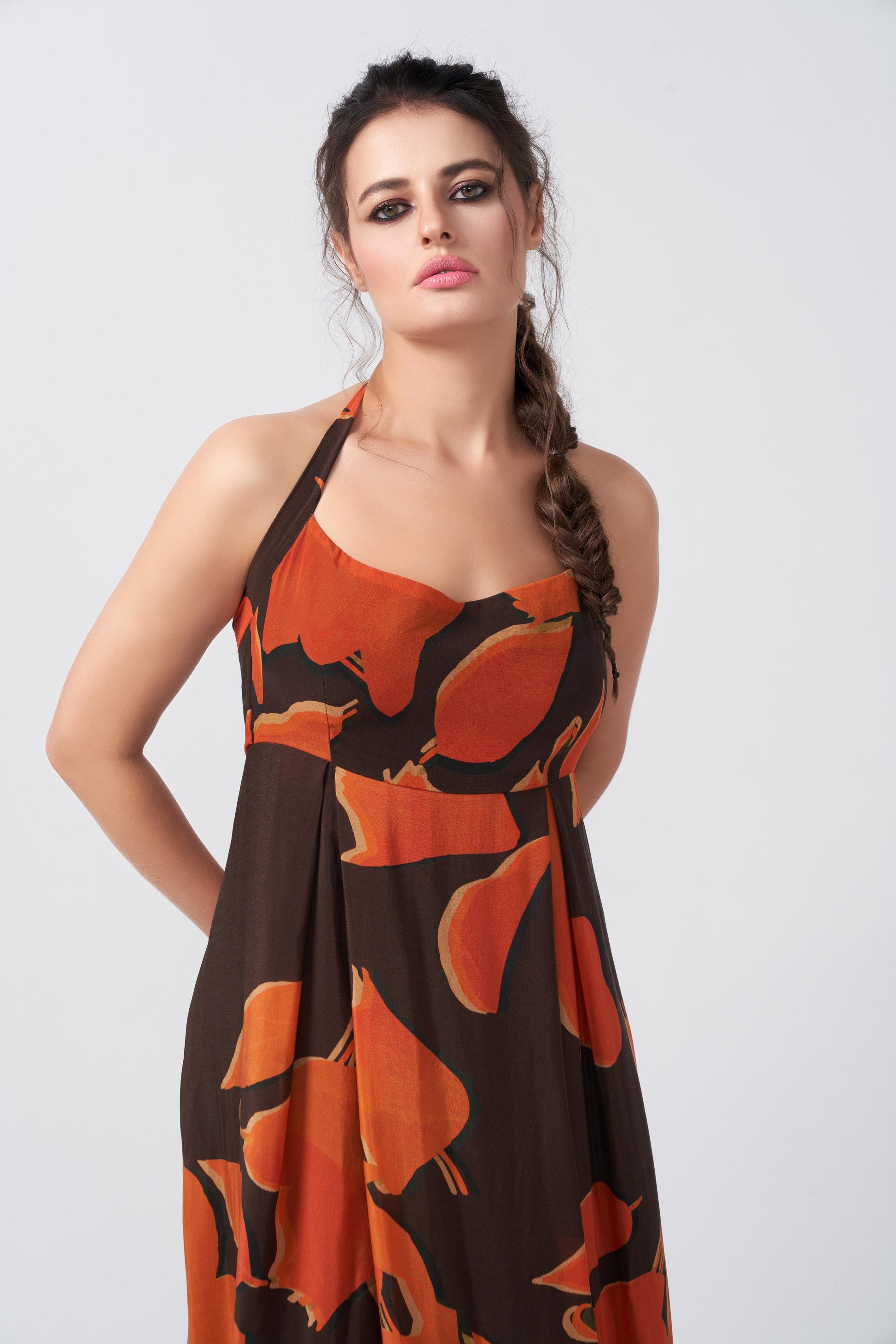 Close-up of model in halter neck orange abstract dress, focusing on the neckline and upper bodice fit.