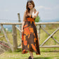 Side view of the model in orange and brown abstract dress, showing movement and flattering silhouette.
