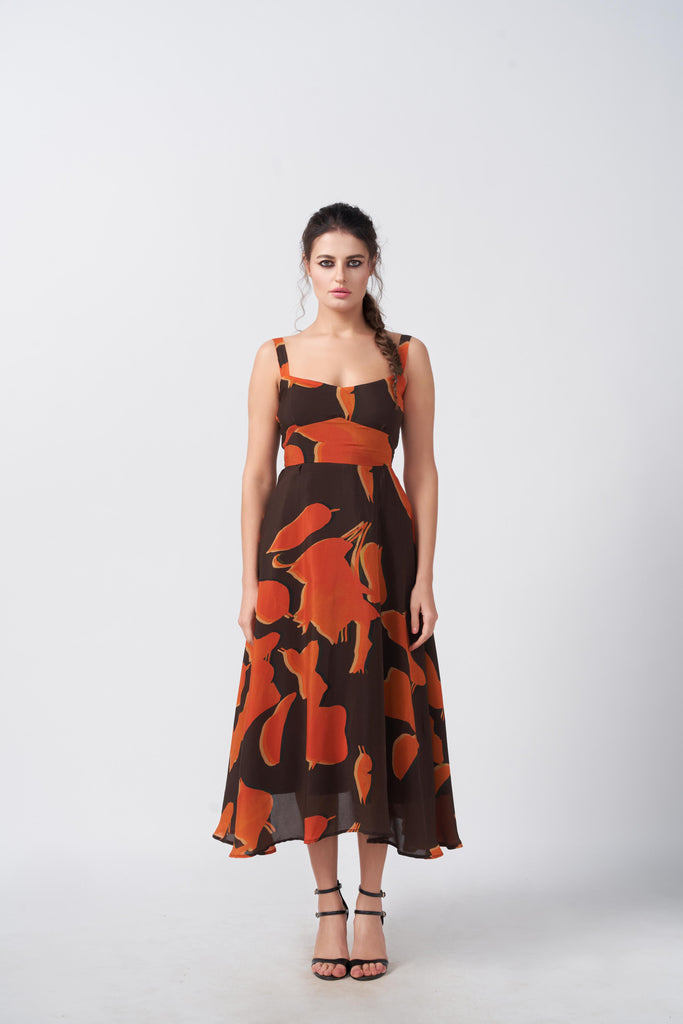 Model facing forward in orange and brown abstract print midi dress, showcasing the silhouette and square neckline.