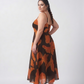 Close-up of orange and brown abstract print on smooth crepe midi dress with a fluid drape