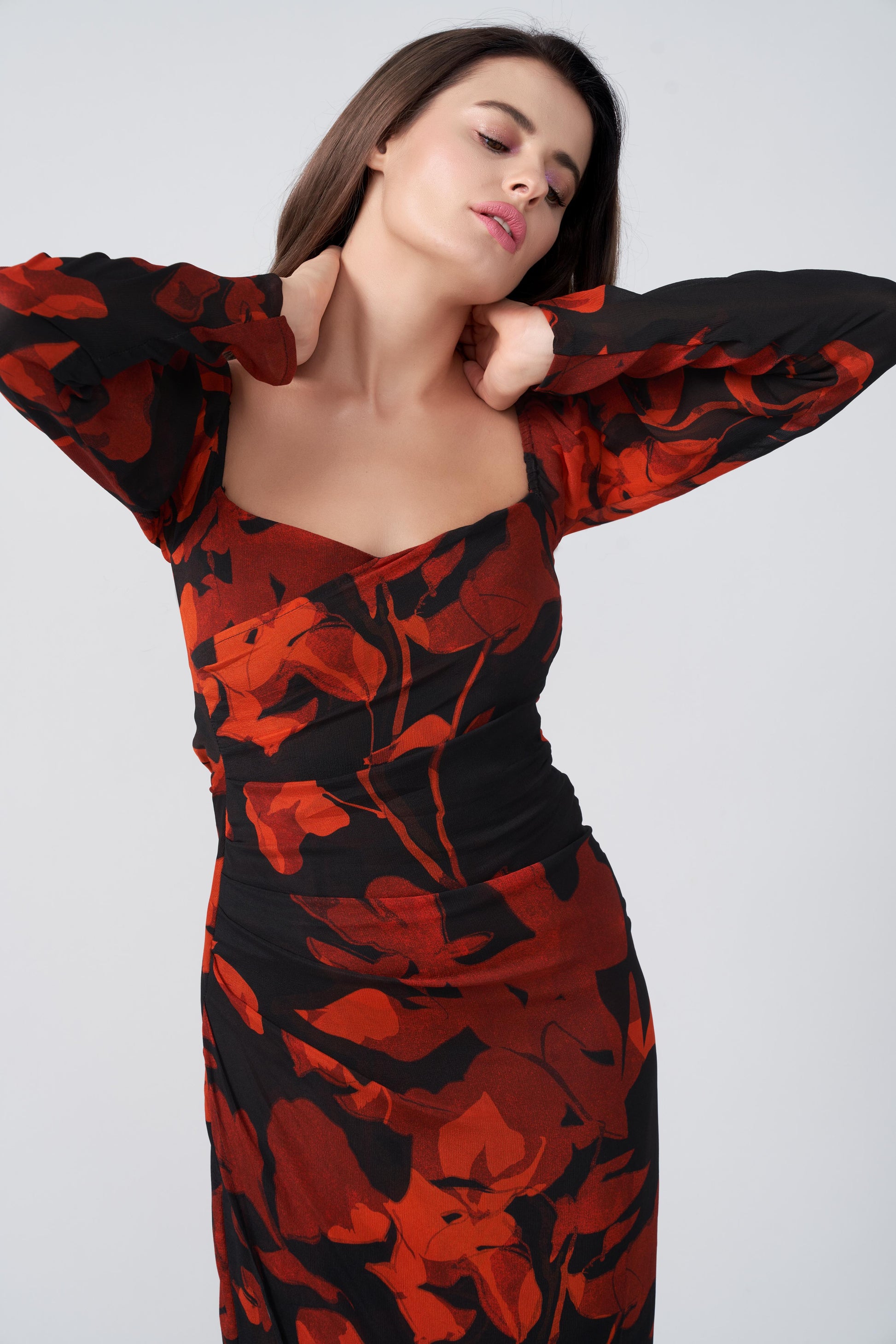  Close-up of overlapped neckline and fitted bodice in orange and black floral print.