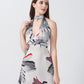 Model standing front-facing in a white and grey floral print dress with red accents and knot front detail.